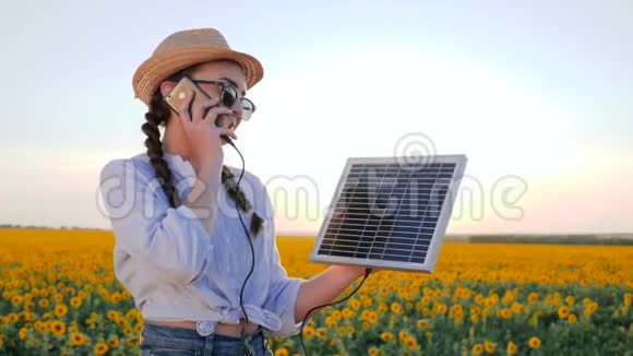 生产能源妇女在背光谈话电话和保持太阳能电池跟踪太阳充电电池视频的预览图