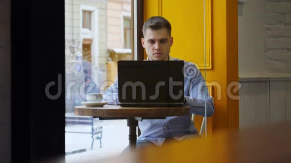 年轻的商人用笔记本在咖啡馆喝咖啡视频的预览图