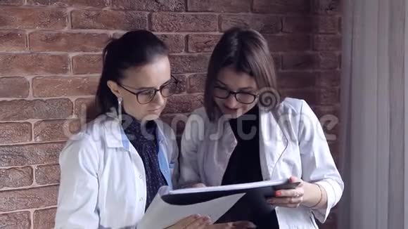 两名女医生在档案中查看医疗记录并咨询诊断智能专业保健视频的预览图