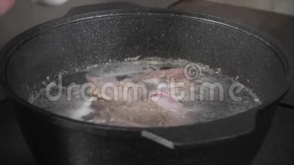 厨师烧盐传统牛肉汤与蔬菜骨头和配料在锅烹饪食谱烹饪中的汤视频的预览图