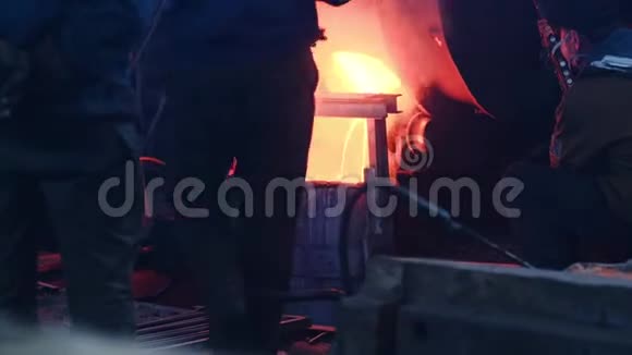 工人们在工厂里倒了熔化的金属库存录像铸造熔融金属的工人和头盔控制过程视频的预览图
