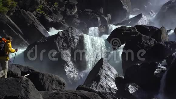 一名游客接近一个岩石瀑布的足迹视频的预览图