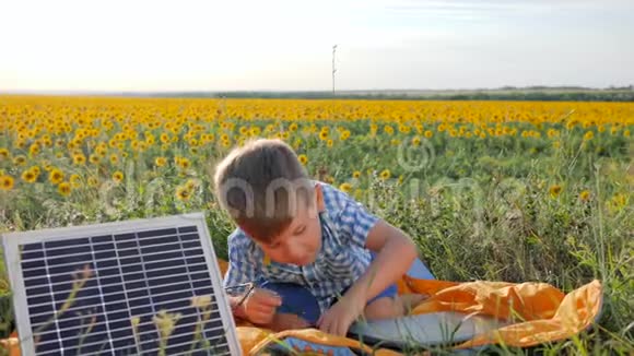 环境友好孩子在背景场上展示类似太阳能光伏电池板附近的手势男孩使用视频的预览图
