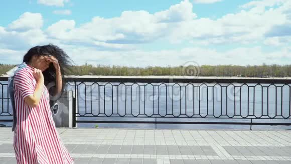 时髦的黑发女郎走在堤边视频的预览图