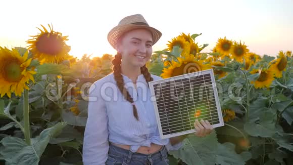 女性在背光中表现出认可的象征手里拿着太阳能电池快乐的女孩手里拿着太阳能电池板视频的预览图