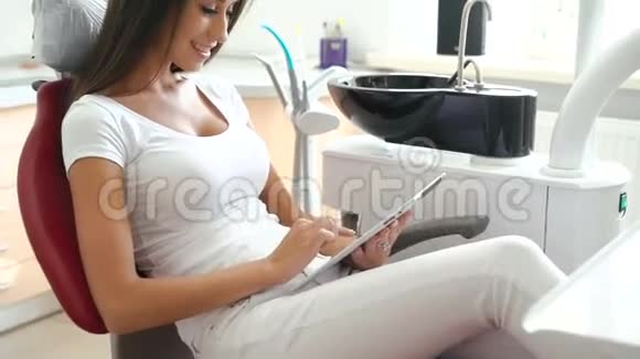 坐在牙医椅上用药片的女人视频的预览图