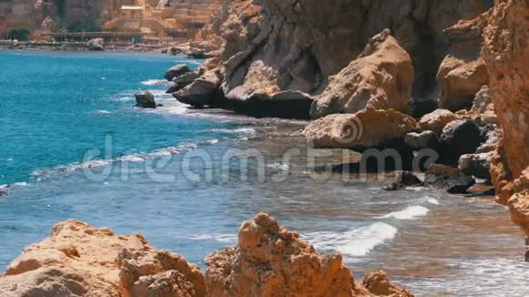 埃及的洛基海滩海滩在一个海湾的海岸线与波浪在蓝色的海洋和珊瑚礁慢动作视频的预览图