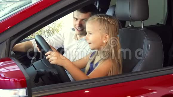 一个小女孩和她爸爸坐在车里假装转动方向盘视频的预览图