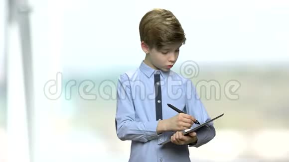 男孩在数字平板电脑上做笔记视频的预览图