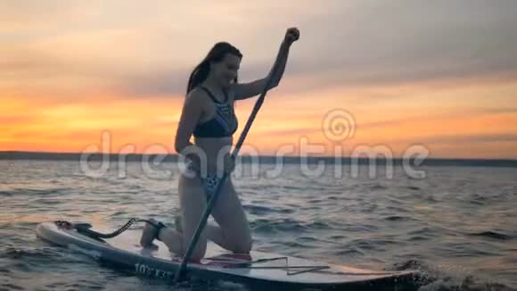 美丽的女士在日落时冲浪自由冒险的概念视频的预览图