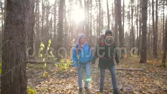 徒步旅行和自然旅行的概念秋天在森林里的一对徒步旅行者视频的预览图
