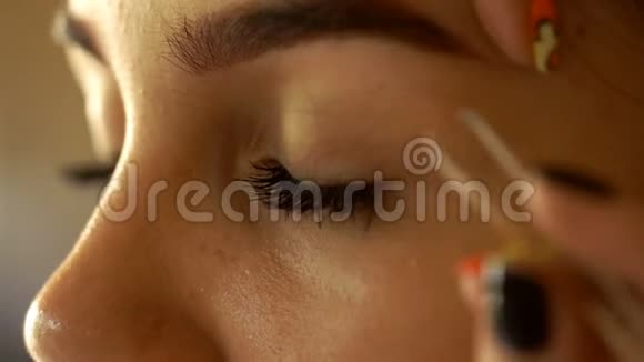 化妆师用镊子调整眉毛年轻女孩视频的预览图