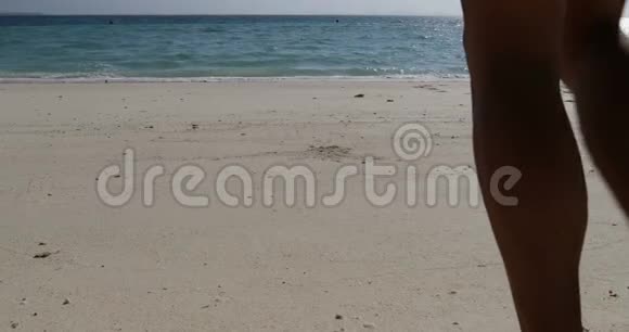 在海滩特写镜头中男性和女性的腿正在水中后景情侣裸食漫步沙滩视频的预览图