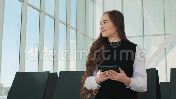 乘客旅客女士在机场等待航空旅行使用平板智能手机年轻的商界女性视频的预览图
