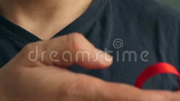 一个人在衬衫上贴了一条红色意识丝带艾滋病毒艾滋病视频的预览图