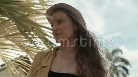 戴草帽的漂亮女人在热带度假胜地享受夏天的肖像视频的预览图