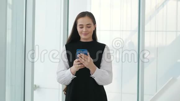 办公室里有一部手机背景是机场航站楼年轻的商务女性视频的预览图