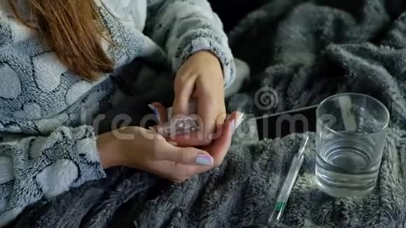 有发烧的年轻女人吃药视频的预览图
