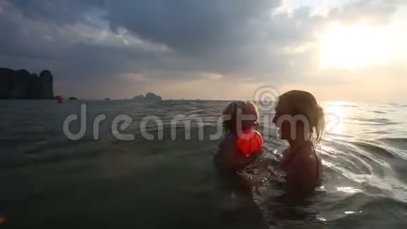 日落时分与母亲在海上沐浴的女孩视频的预览图