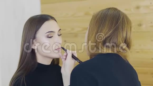 性感年轻模特嘴唇上的红色口红专业化妆整理轮廓细节特写视频的预览图