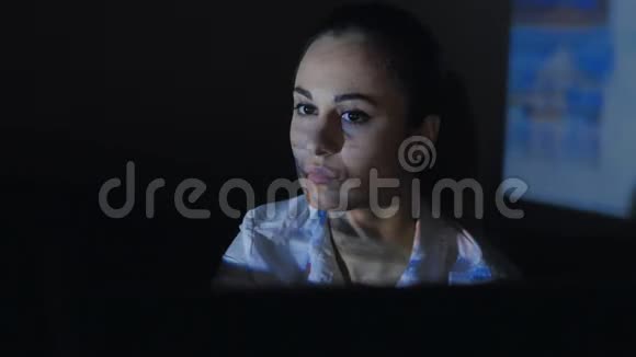 年轻女子在黑暗的房间里坐在电脑前上网视频的预览图