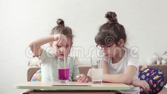 实验的准备工作孩子们在实验室里玩小女孩正在玻璃里搅拌化学试剂视频的预览图