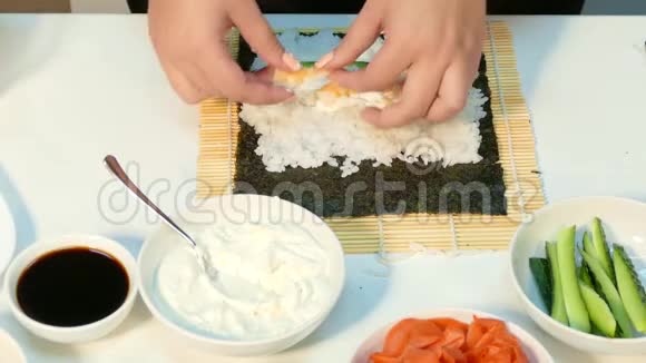 厨师把虾和红鱼子酱放在寿司卷馅里视频的预览图