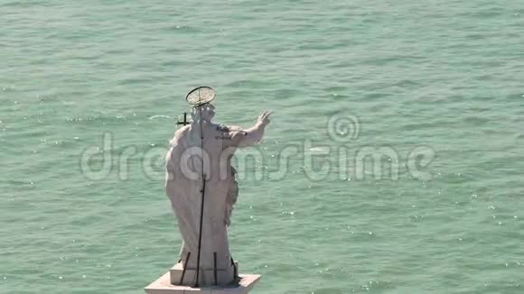 在阳光明媚的日子里站在河边的神圣雕像用手势祝福水手视频的预览图