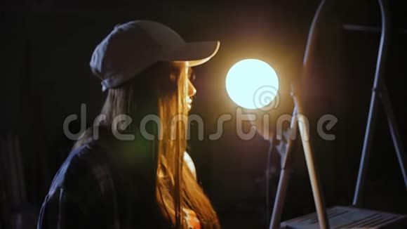 一位戴着棒球帽的年轻女子长发矗立在汽车修理店的中间视频的预览图
