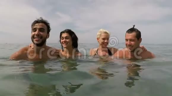 两个在海边玩的朋友一起在海上游泳动作镜头是年轻人一起在海滩上游泳视频的预览图