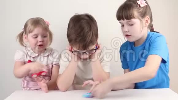 三个快乐的孩子在桌上玩旋转体视频的预览图