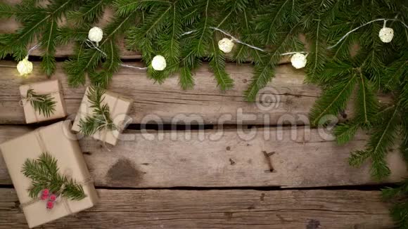 白色木板上有礼品盒的冷杉树枝做成的圣诞框架视频的预览图