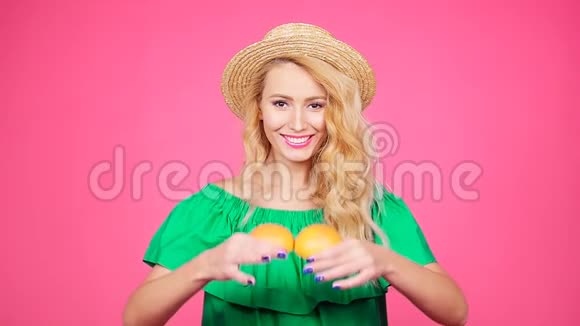 快乐的年轻女人用两个半汁的葡萄柚代替眼睛视频的预览图
