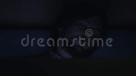 一个疲惫的年轻人睡得正香一只手伸到头上躺在笔记本电脑旁的床上一个人晚上工作过度视频的预览图