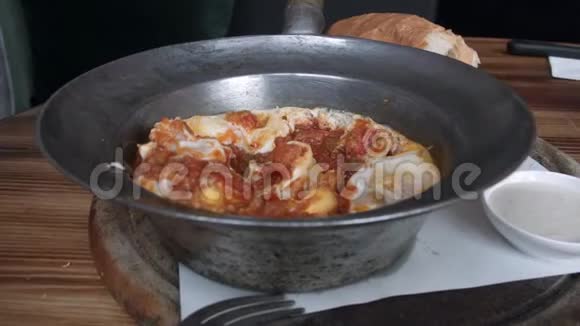 把面包蘸上沙克舒卡水煮鸡蛋和西红柿一起放在煎锅里以色列阿拉伯中东美食视频的预览图