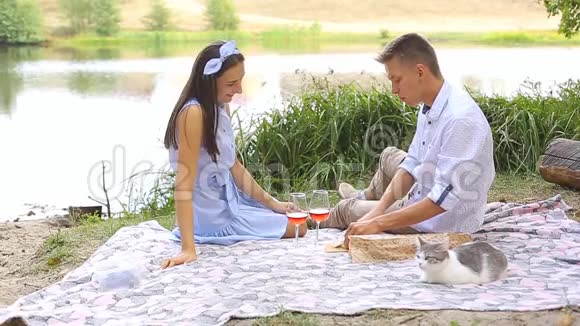 在湖边的森林里一对相爱的年轻夫妇的浪漫野餐视频的预览图