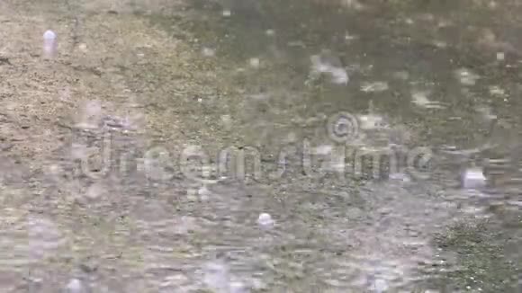 特写镜头拍摄雨落在雨路水面视频的预览图