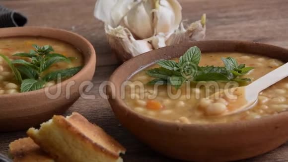 提供传统的热豆汤玉米面包大蒜和橄榄油素食健康菜视频的预览图