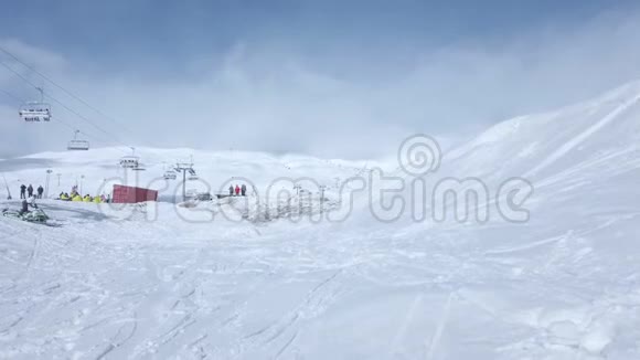 一个骑着雪车的人从蓝天的山脊上跳下来云和新鲜的白雪视频的预览图