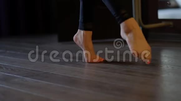 舞女赤着脚踩着脚趾头踩在芭蕾酒吧的地板上视频的预览图