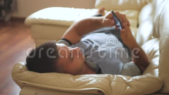 男人在家里沙发上用手机视频的预览图