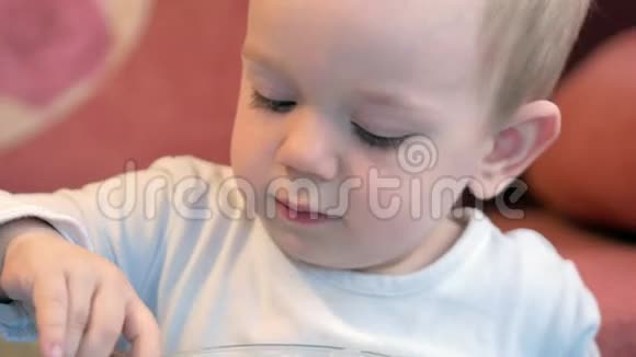 一个可爱的小男孩在孩子们的桌子上吃粥和肉片家用家具视频的预览图