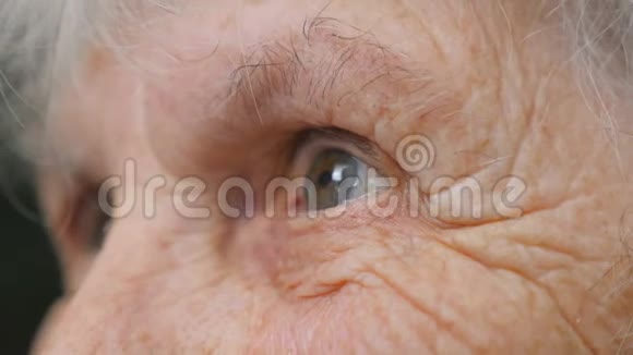 老妇人望着远处一位有皱纹的老太太的眼睛奶奶的特写肖像视频的预览图