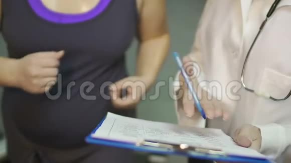 护士将化验结果以纸张显示给在跑步机上跑步的胖女孩医疗保健视频的预览图