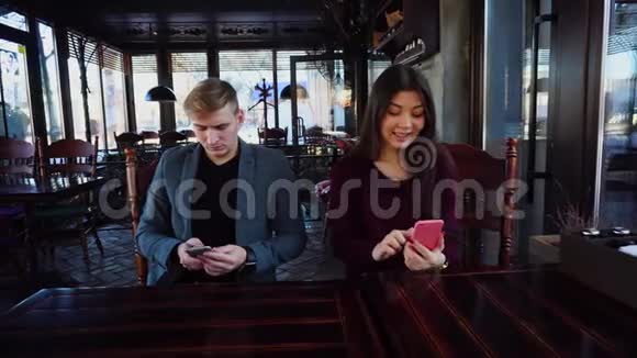 手里拿着智能手表的男朋友和女朋友一起测试智能手机视频的预览图