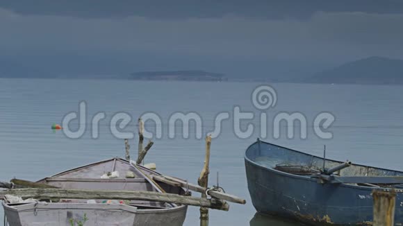 两艘旧渔船坐在海湾上视频的预览图