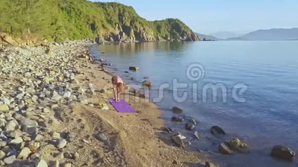 FlycamView女孩在海面上对着日出摆瑜伽姿势视频的预览图