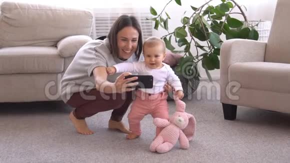 妈妈用手机和小女孩自拍视频的预览图