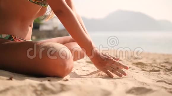 从泰国热带海岛海滩的女性手中掉落的白沙4K慢动作视频的预览图