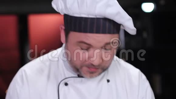 中年厨师在厨房做饭白色制服餐厅视频的预览图